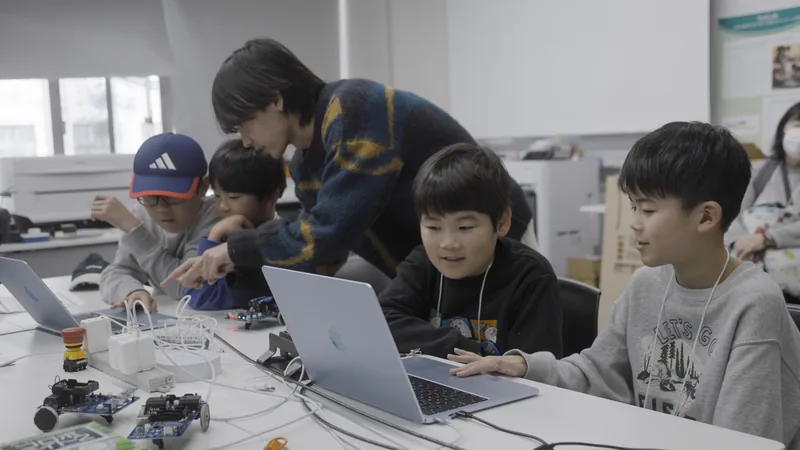 Children learning programming with staff