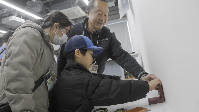 プレス模型で缶バッジづくりを体験する子ども