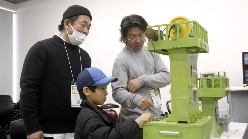 A child making a badge with a model press, watched by an exhibitor and a parent